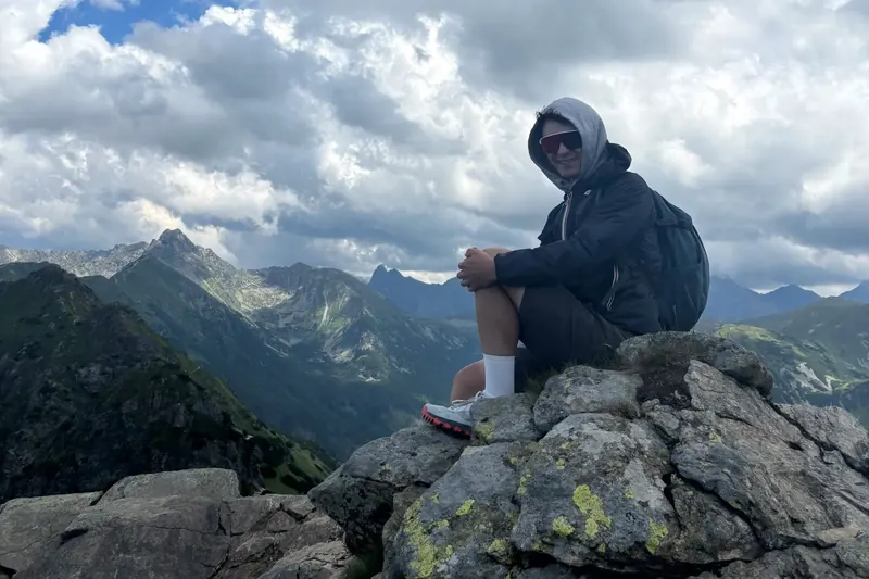 Turysta odpoczywa na skale na tle Tatr