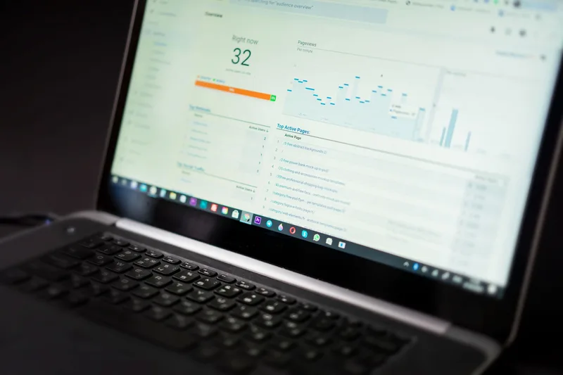 Laptop z panelem analitycznym wyświetlającym wykresy i dane